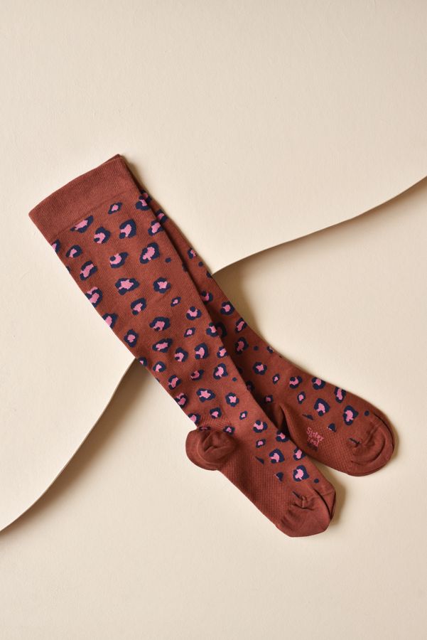 Chaussette de compression léopard, fond terracotta
